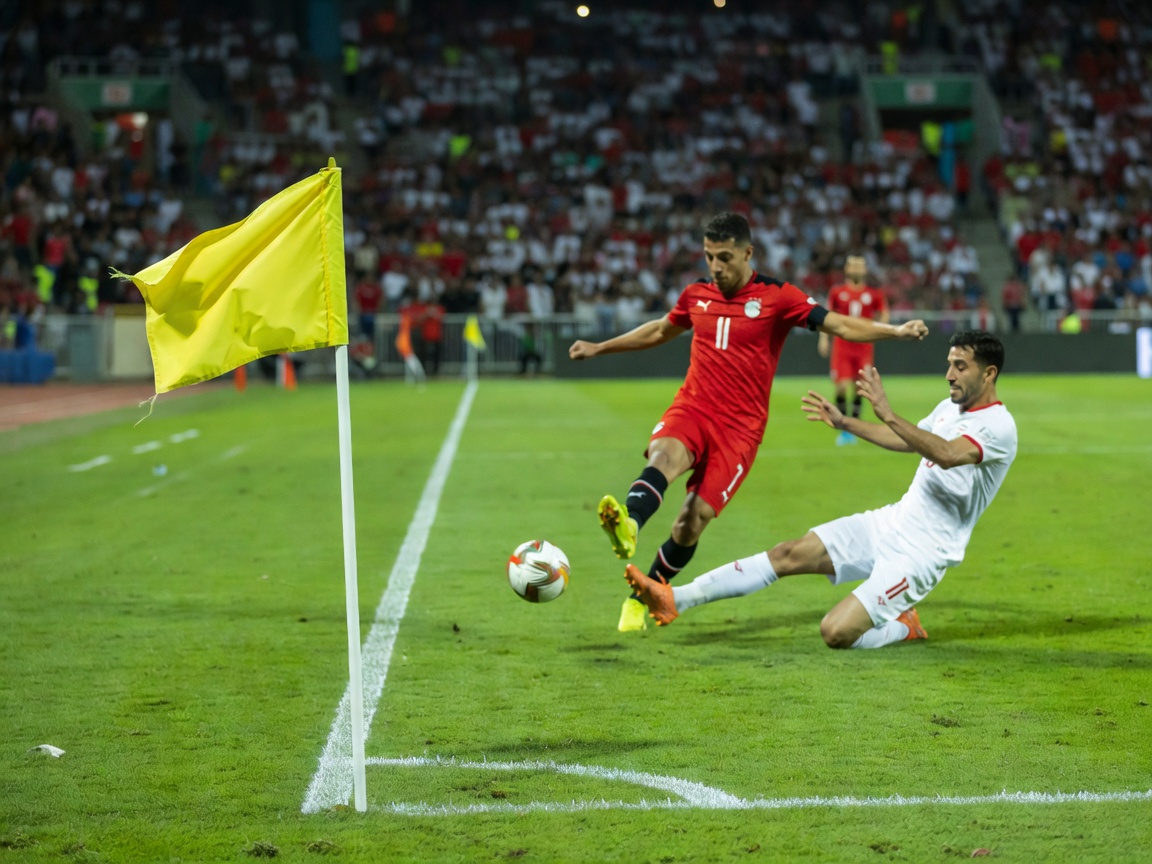 A yellow corner flag fluttering in the breeze during the Egypt vs Iran fixture